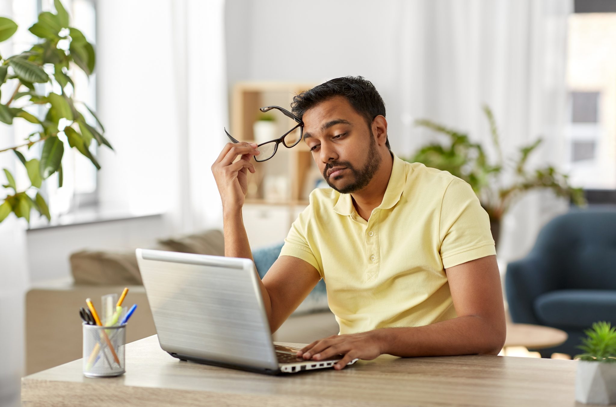 bored man with laptop working at home office