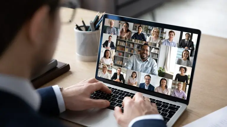 Businessman talking to team of colleagues on online video conference